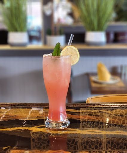 A pink lemonade with mint and lemon