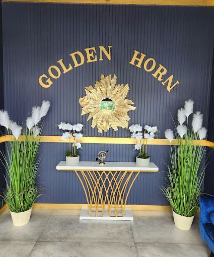 The Golden Horn sign and a gold sunburst mirror at the entrance